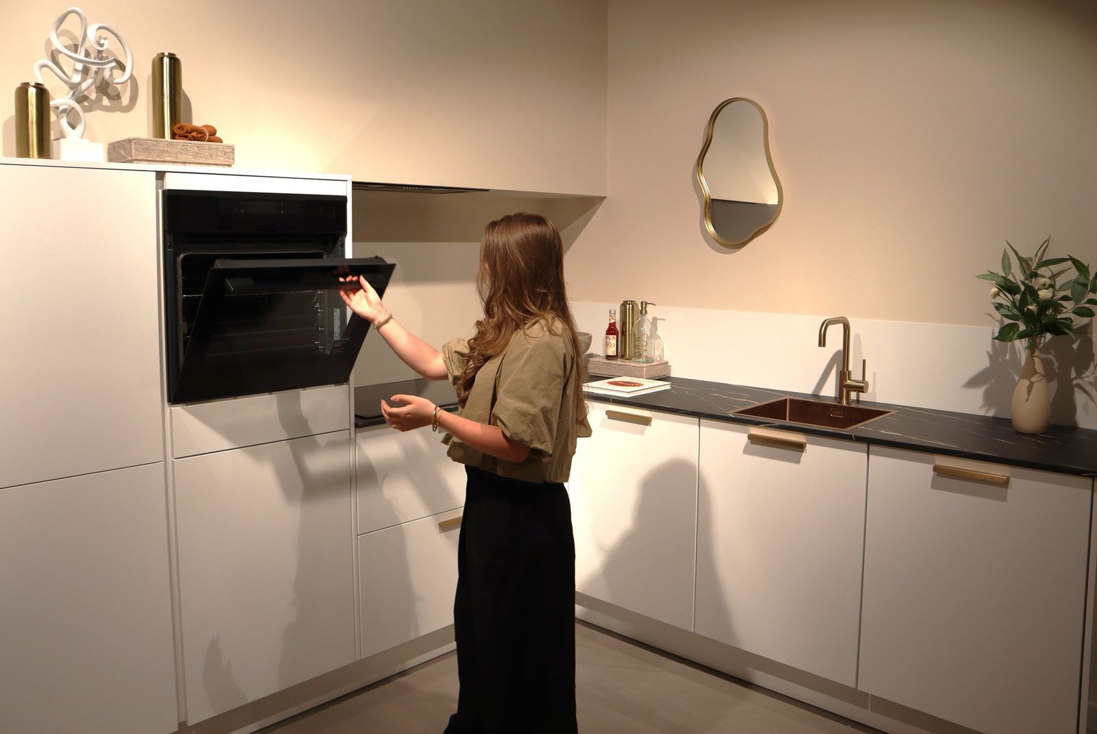 Bewoner opent de oven in de nieuw opgeleverde keuken